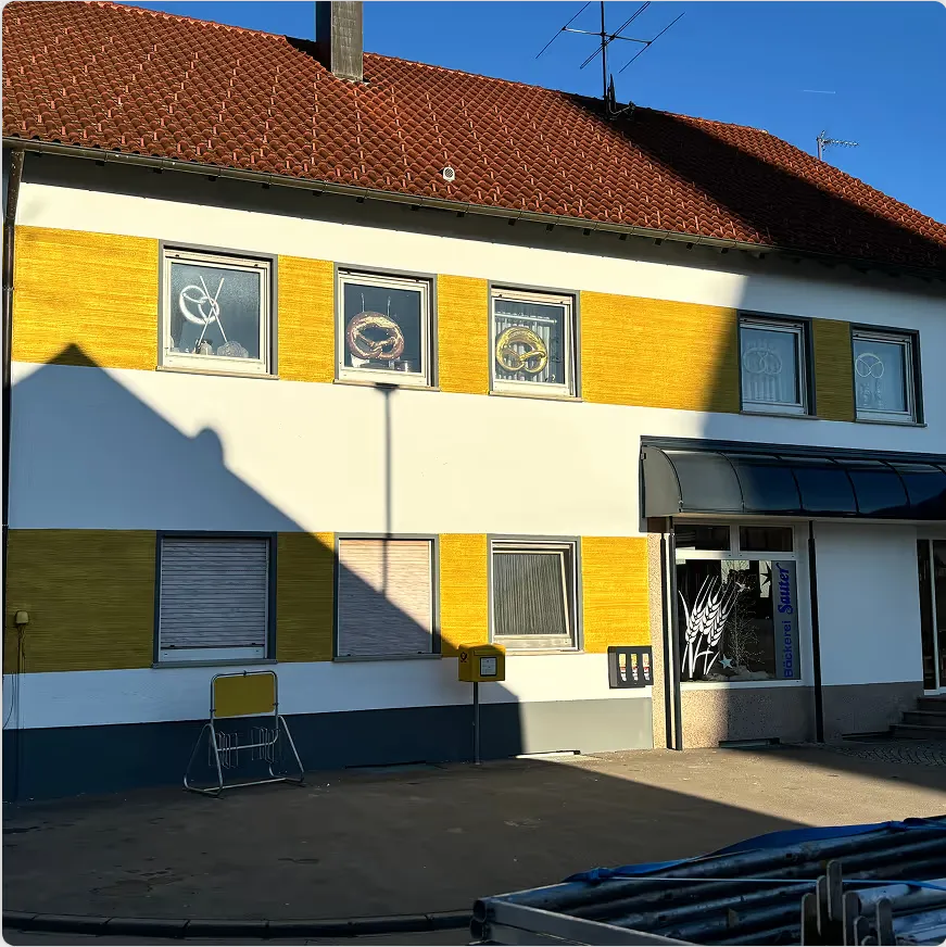 Gebäude mit gelben Fassadenflächen und Ladengeschäft im Erdgeschoss