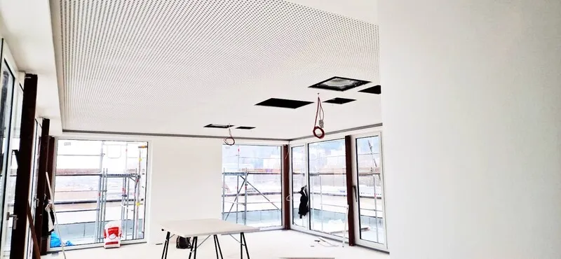 Großer heller Raum mit Akustikdecke und Fensterfront